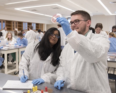 Two students study a test tube